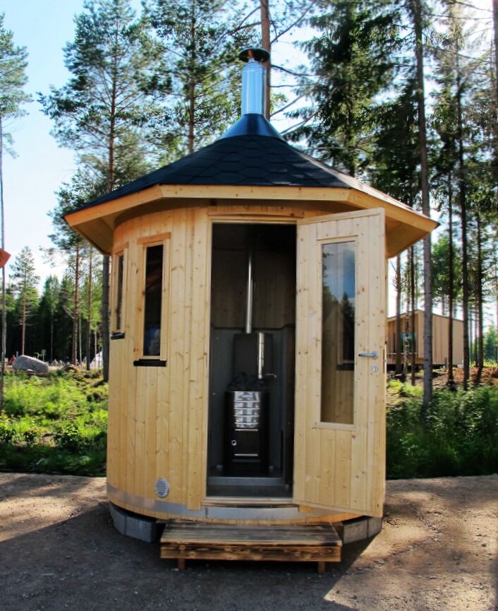 Vertikal Sauna Oskar mit geöffneter Tür, Blick ins Innere auf Holzofen mit Warmwasserbehälter