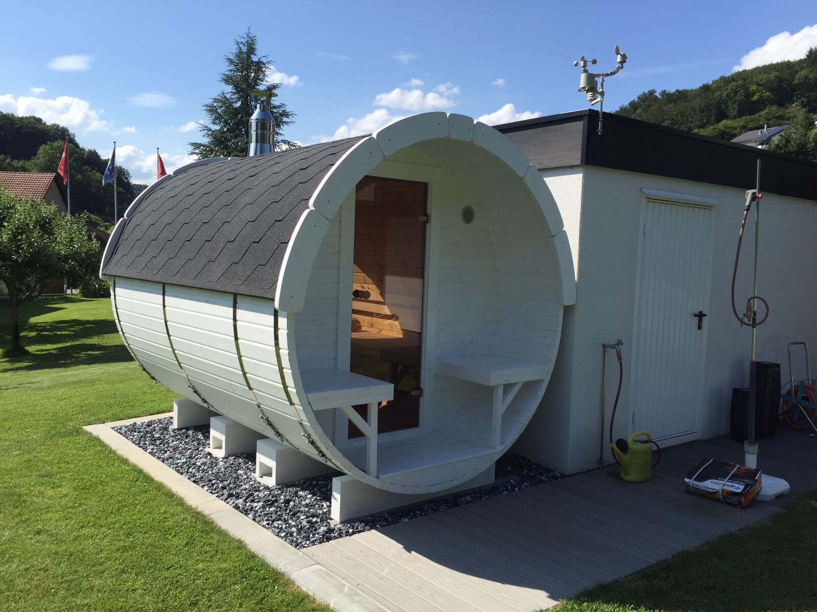 Fass-Sauna Premium in weiß mit schwarzen Schindeln im Garten