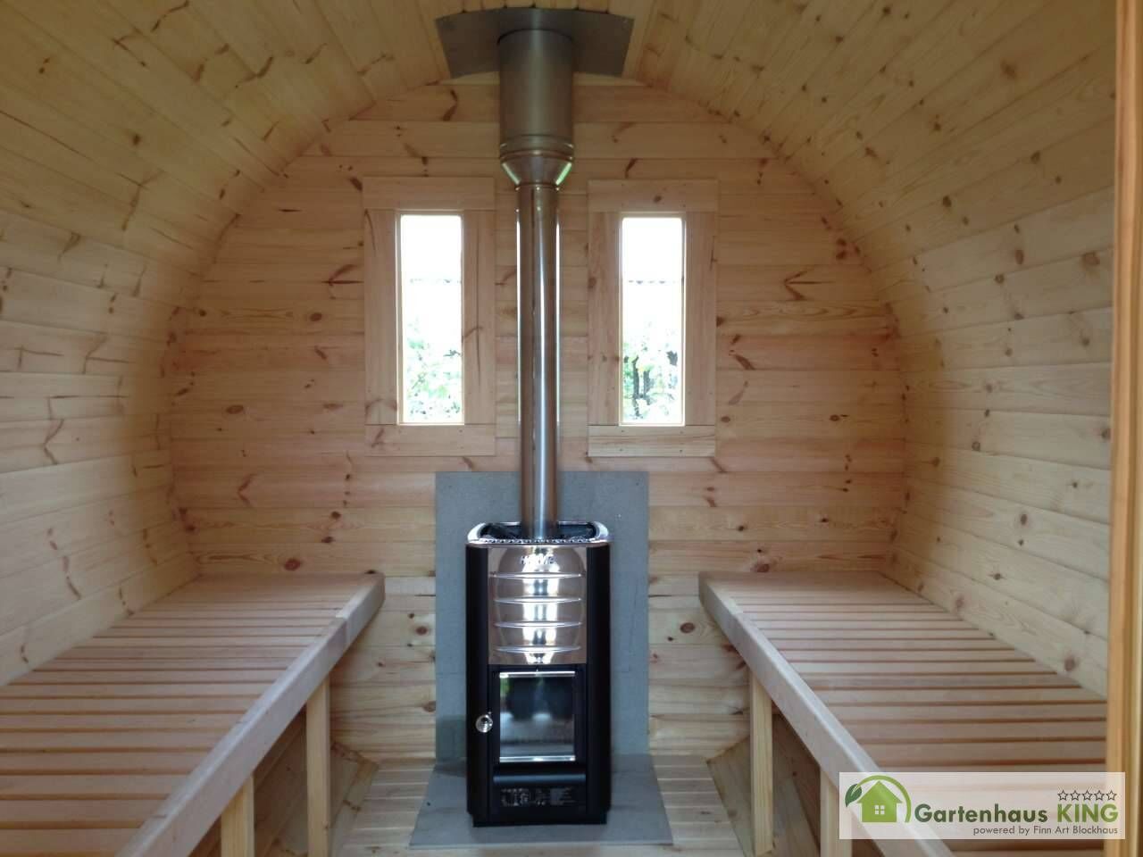 Finn Art Fass-Sauna Premium Innenansicht mit Holzofen und Dachdurchführung des Rauchabzugs, Hitzeschutzplatten hinter und unter dem Ofen