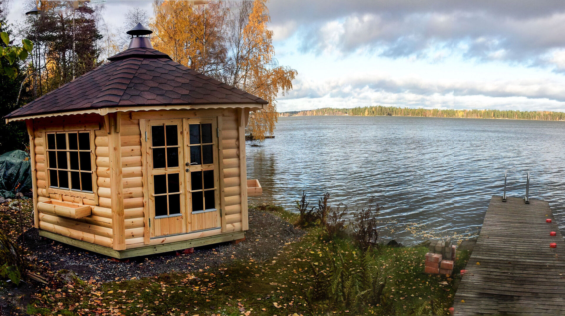 Grillpavillon Victoria 9,2 m² braun mit roten Schindeln am See