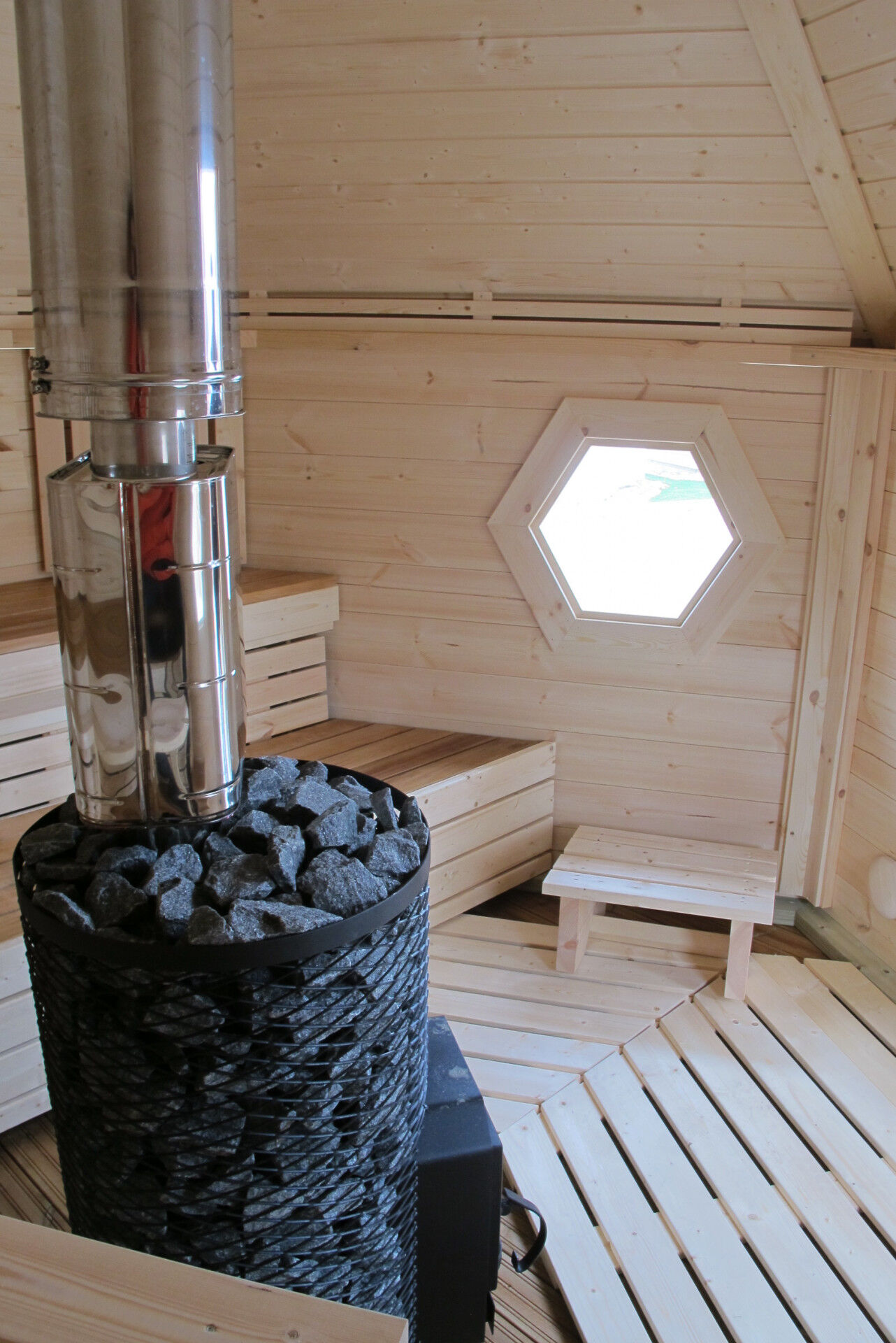 Arctic Saunakota 9 m² Innenansicht Holzofen mit Wasserbehälter und Bänken
