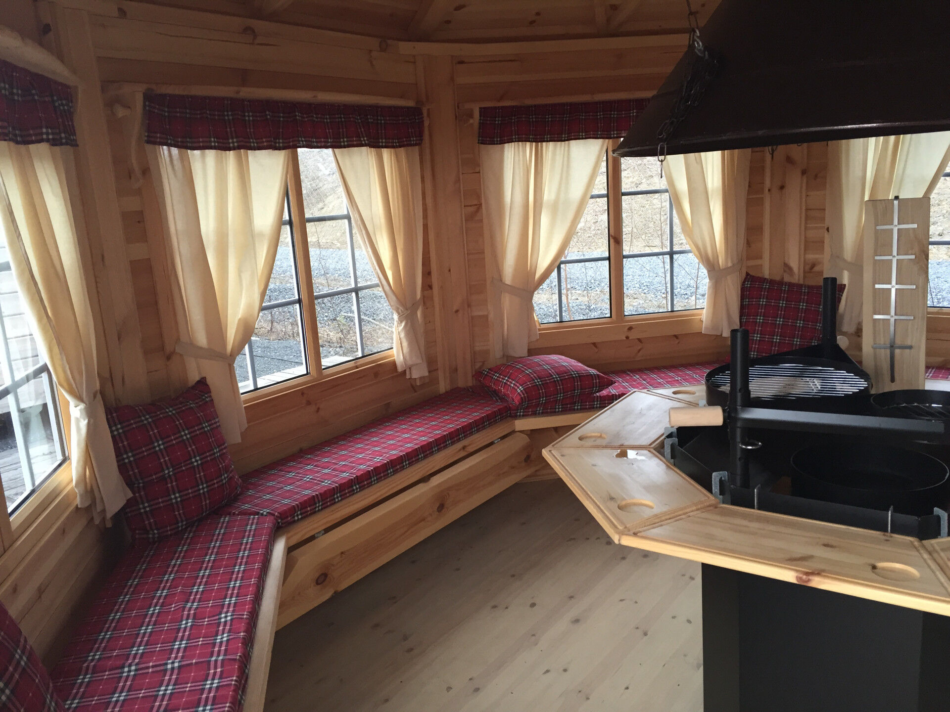 Grillpavillon Victoria Oval 18 m² Innenansicht Bänke mit roten Sitzkissen, Deko